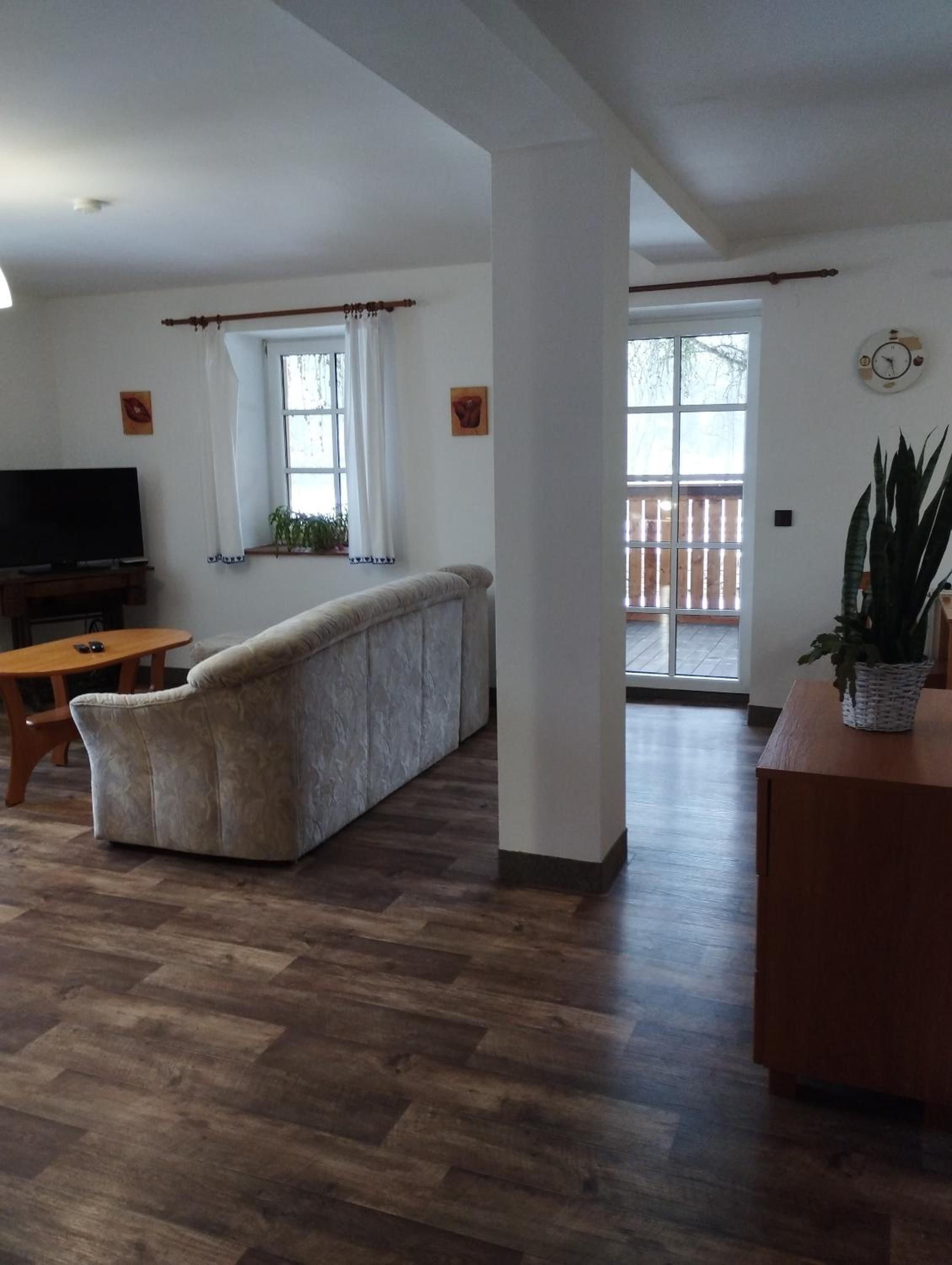 A living room with a sofa, a television, and a wooden coffee table.