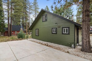 A green building with a sloped roof, a chimney, and a small porch. - Happy On The Lake (Big Bear Lake)