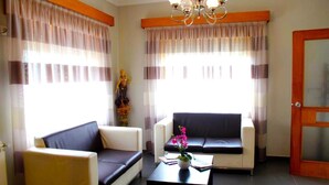 Sala de estar com dois sofás, uma mesa de centro e um lustre.