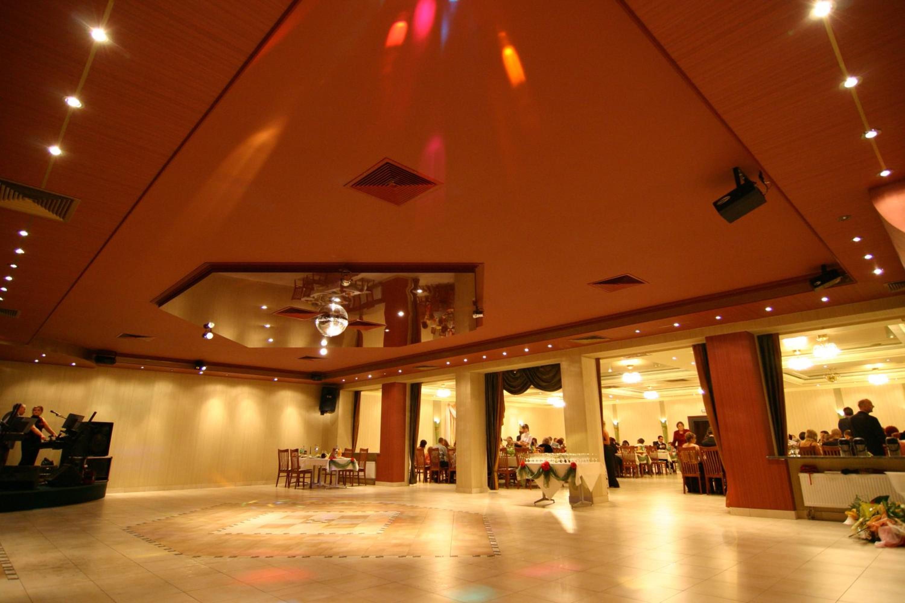 Una sala ampla amb una pista de ball central, diverses zones d'estar i un escenari.