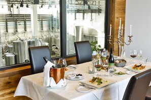 A dining table set with a copper bucket, wine glasses, and plates of food. - Trippelgut Schlafgut (Feldkirchen in Kaernten)