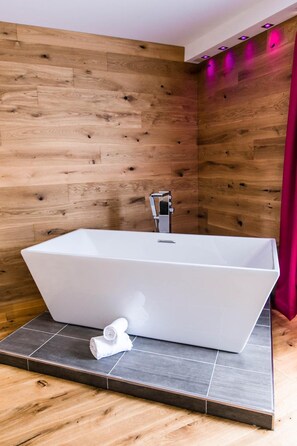 A modern bathroom with a freestanding bathtub, a shower, and a towel. - Trippelgut Schlafgut (Feldkirchen in Kaernten)