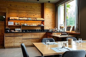 A wooden interior with a kitchen counter, dining table, and chairs. - Hotel Bel Sit (Valle di Cadore)
