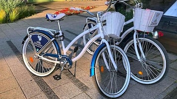 A bicycle with a basket and a seat bag, parked on a paved surface.