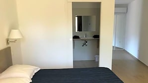 Ein Schlafzimmer mit einem Bett, einem Nachttisch und einer Lampe.