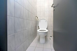 Un baño con inodoro, porta rollos y bidé.