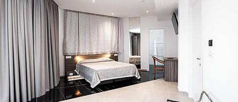 A modern bedroom with a bed, a desk, and a chair.