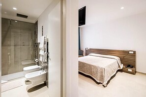 Une salle de bain moderne avec une douche à l’italienne et des toilettes séparées.