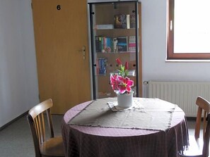 Ein Zimmer mit einem runden Tisch, einem Bücherregal und einer Tür, die mit der Nummer 6 gekennzeichnet ist.