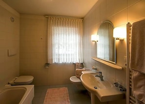 Un bagno con vasca, servizi igienici e lavandino.