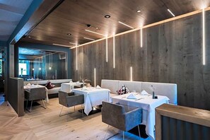 A modern restaurant interior with wooden walls, tables, and chairs. - Alpine Spa Resort Viktoria (Avelengo)
