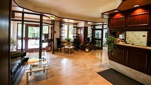 Eine geräumige Lobby mit Empfangstresen, Sitzgelegenheiten und großen Fenstern, die für natürliches Licht sorgen.