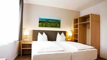 Ein Hotelzimmer mit einem Bett, zwei Nachttischen, einem Kleiderschrank und einem Landschaftsbild an der Wand.