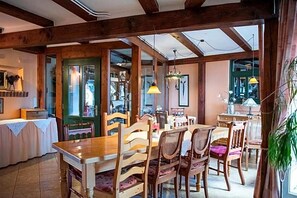 Un comedor con mobiliario de madera, una lámpara de araña y vistas a través de un ventanal.