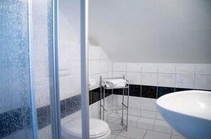Un baño con cabina de ducha, inodoro y lavabo.