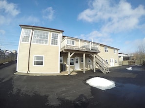 A two-story building with a covered porch and a staircase leading to the upper level. - Admiral S Quay Motel Suites (Saint John)