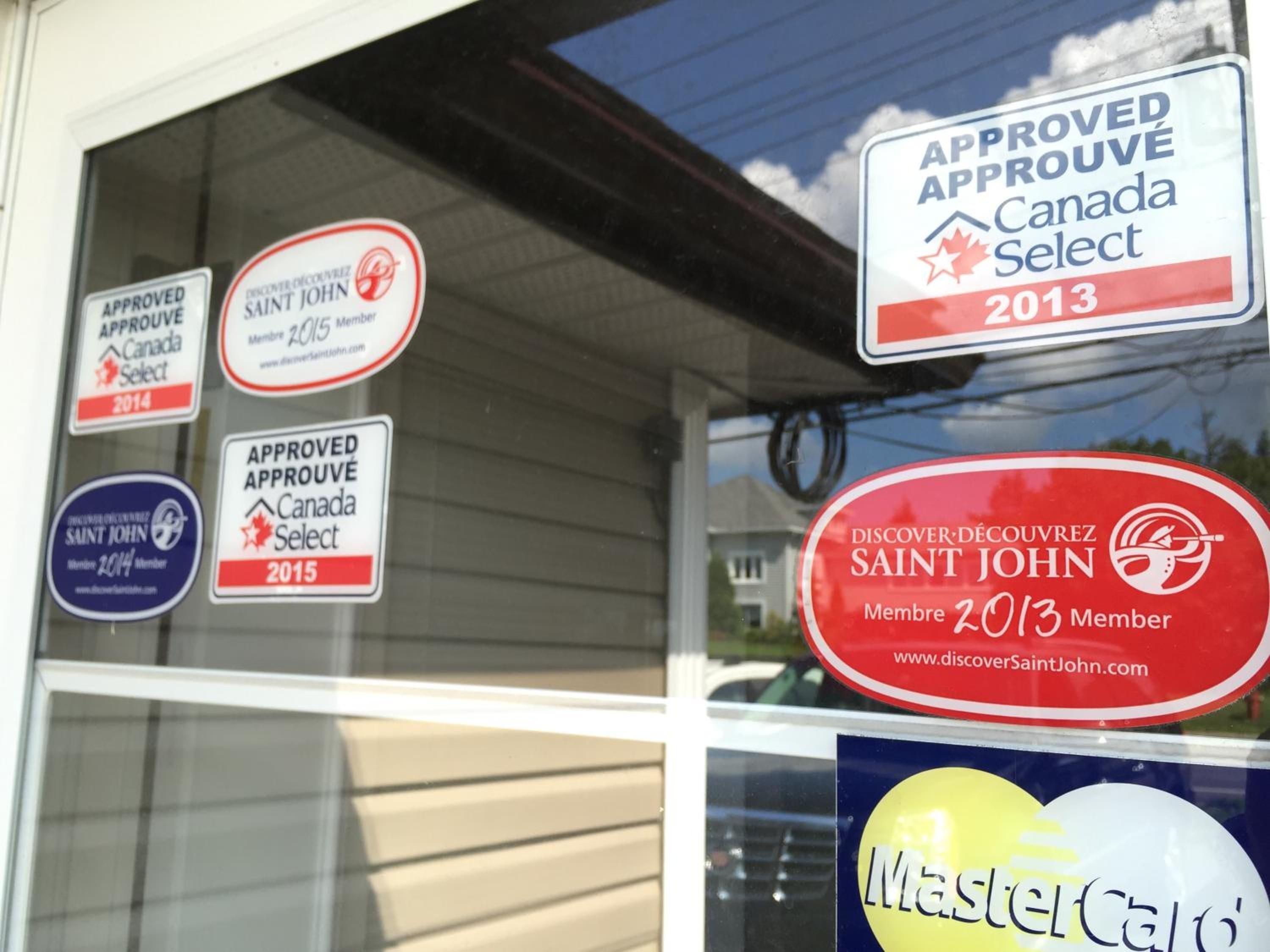 Een raam met verschillende stickers die goedkeuring van Canada Select voor verschillende jaren aangeven.