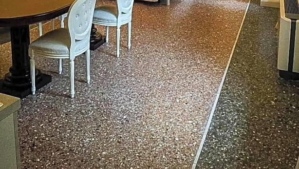 Een kamer met een bed, een tafel met stoelen, een kroonluchter en een kledingkast.