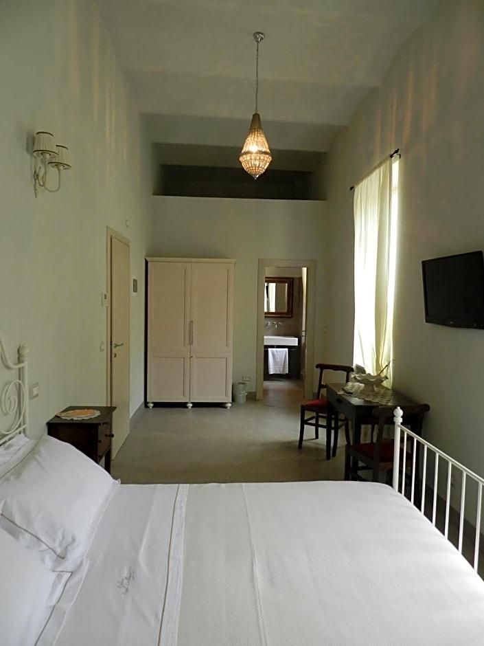 Une chambre à coucher comprenant un lit, un bureau, une chaise, une armoire et un luminaire suspendu.