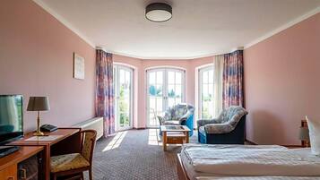 Ein Hotelzimmer mit Bett, Schreibtisch, Stuhl und Blick aus dem Fenster.
