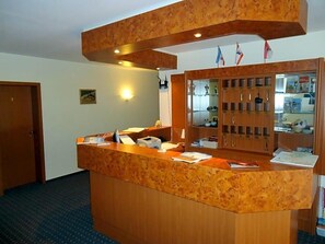 A reception desk with a telephone, a computer, and a glass display cabinet. - Hotel Marianne Und Restaurant Kiek In (Plau am See)