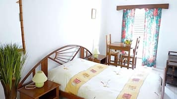 Un dormitorio con una cama de madera, mesitas de noche, un escritorio y una silla.