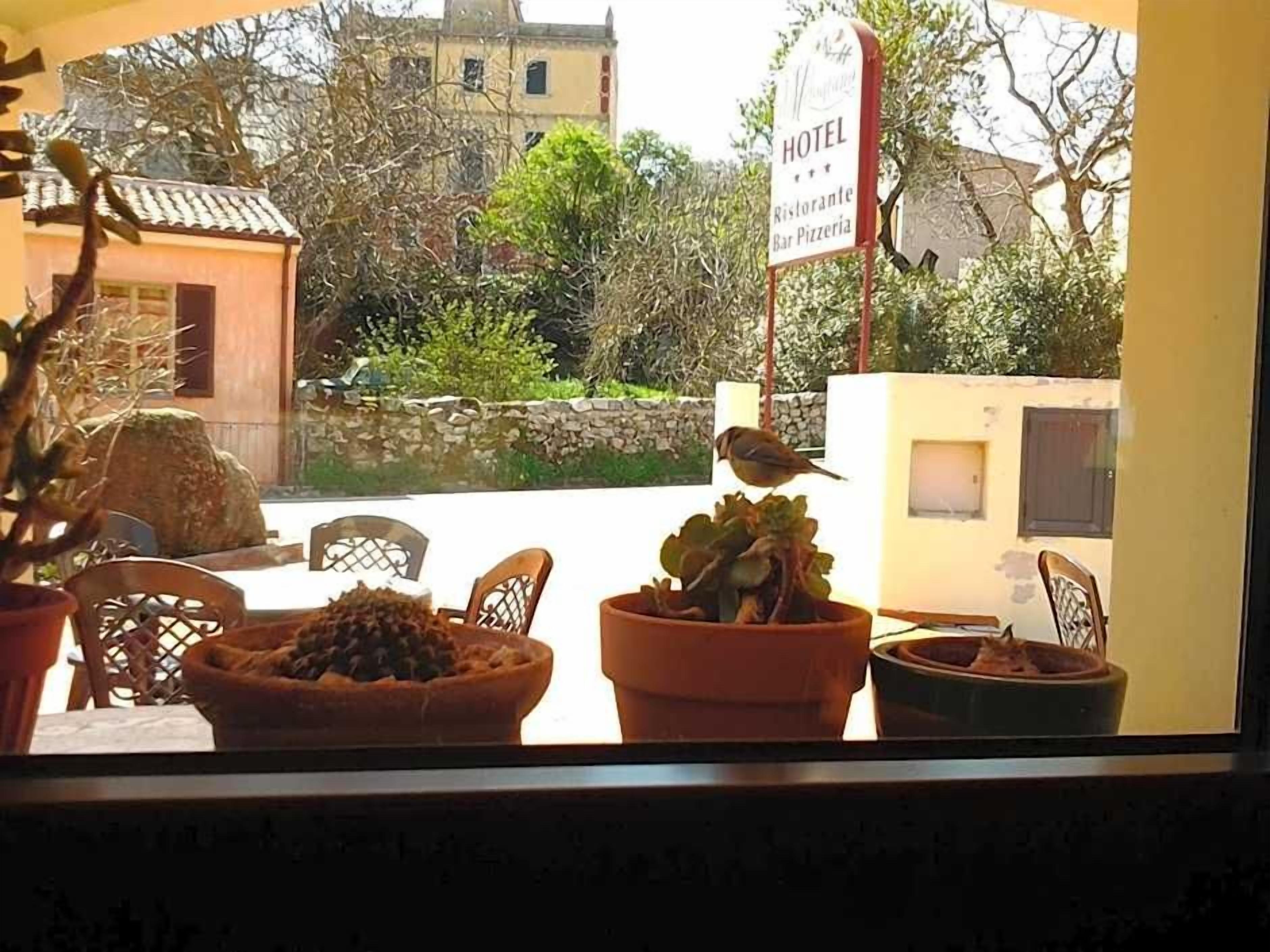 A view from a window with a sign indicating a hotel, restaurant, and bar.
