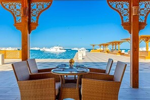 An outdoor seating area with wicker furniture and a view of the sea. - Grand Palace Adults Only 18 Years Plus (Hurghada)