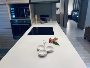 Eine moderne Küche mit einer zentralen Kochinsel, Einbauofen und Essbereich mit Aussicht.