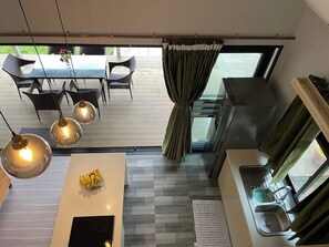A modern kitchen with a dining area, large windows, and a view of the outdoors. - Fare Luna - Comfy New Home in Bora Bora (Bora-Bora)