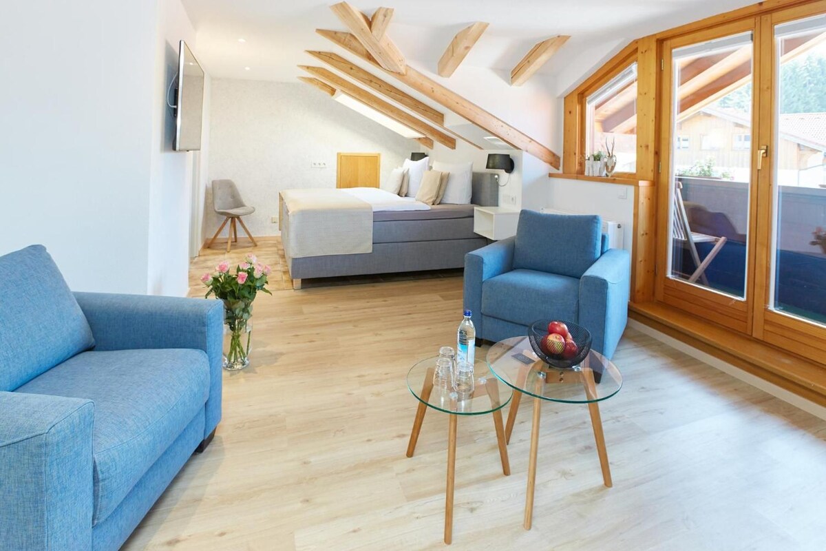 Uma sala de estar moderna com sofá, mesa de centro de vidro e cama com vista.