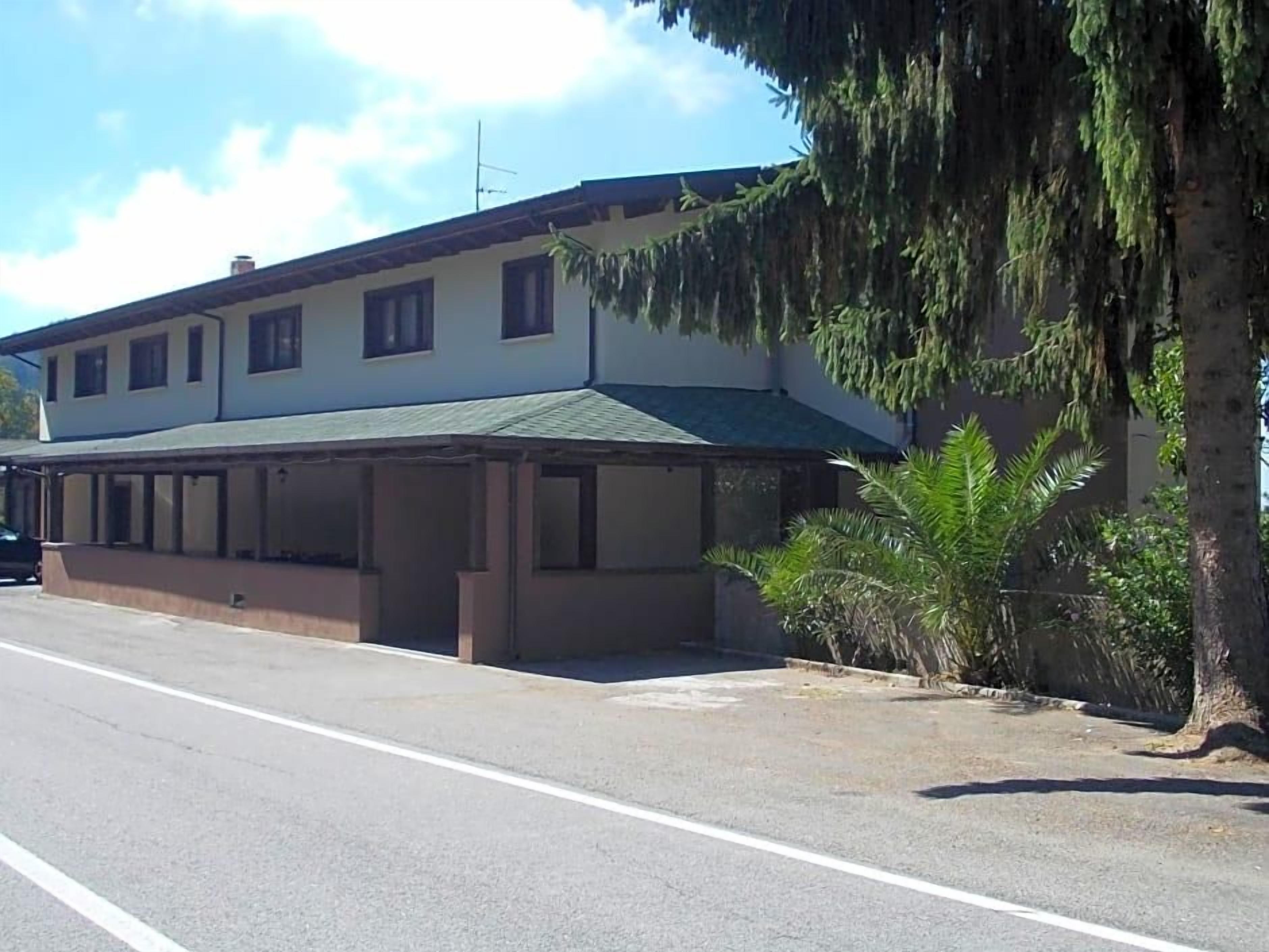 A two-story building with a flat roof and a covered front porch.