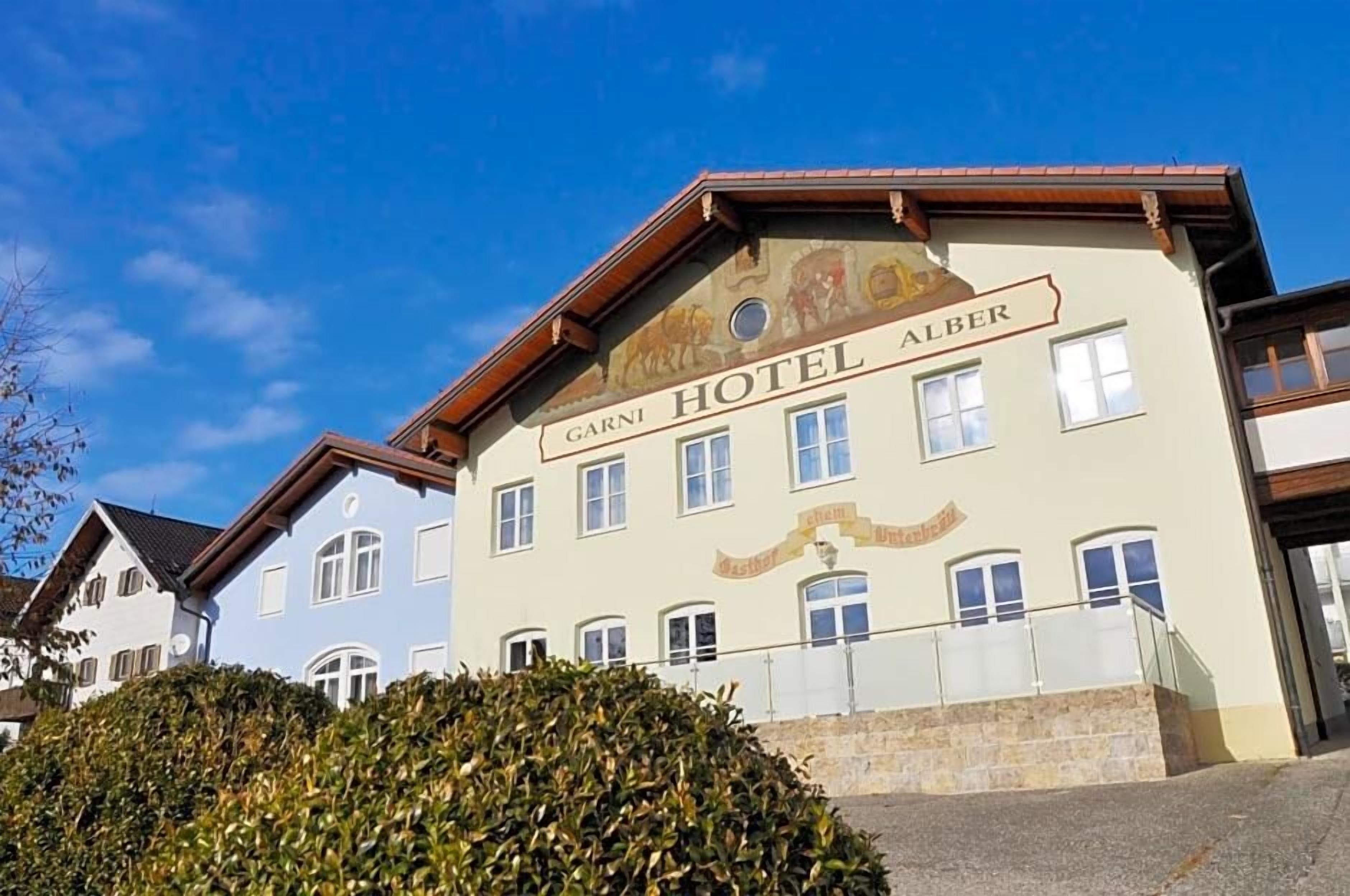 Um edifício de hotel com uma placa que diz 'Garn Hotel Alber'.