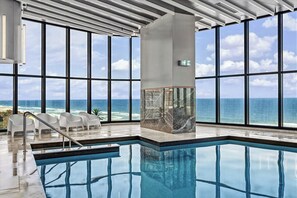 A modern indoor pool with a clear view of the ocean through large windows. - Paradise Coast Luxe in the heart of Surfers Paradise (Surfers Paradise)