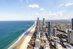 Un paisaje urbano costero con rascacielos, una playa y cielo despejado.