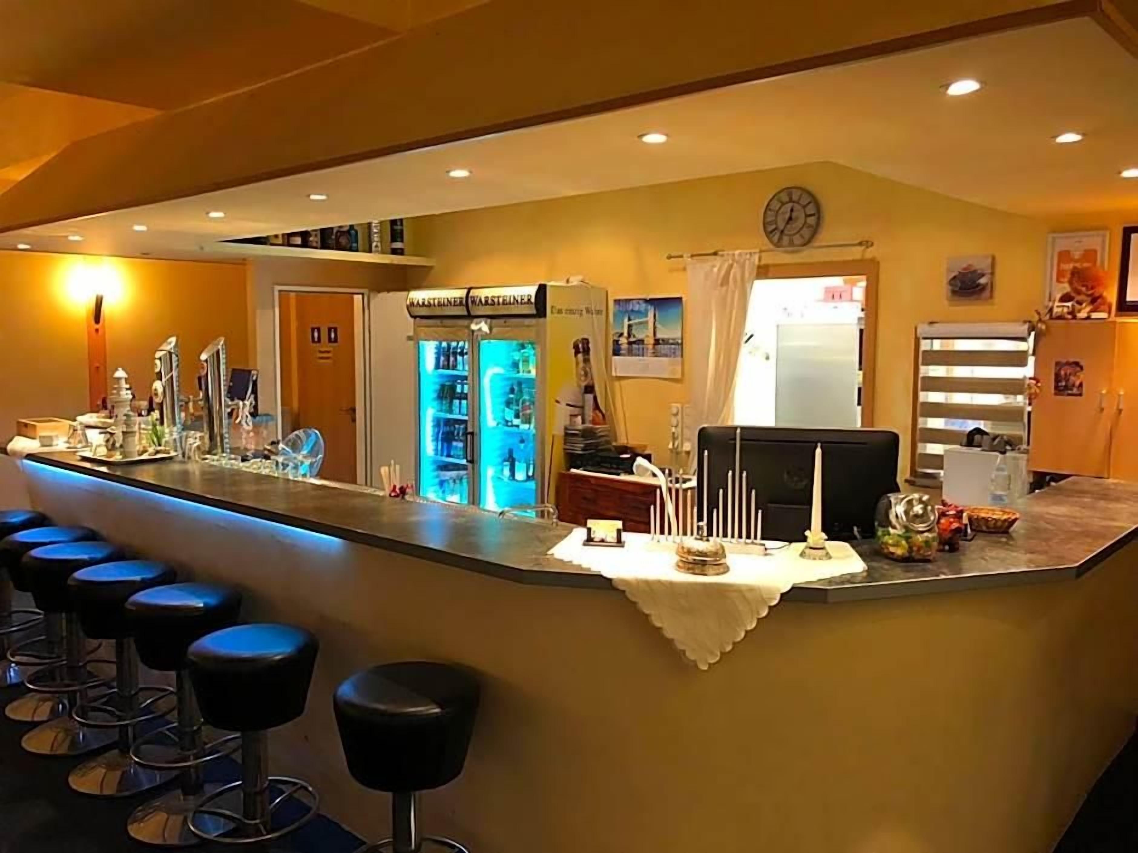 Un coin bar avec des tabourets, un mini-bar et un réfrigérateur.