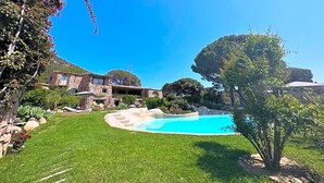 A backyard with a swimming pool, a stone house, and a tree. - Hv Tel Ambassador Palombaggia (Porto-Vecchio)