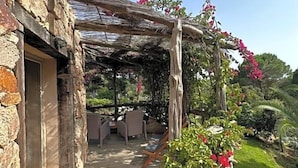 A stone building with a wooden deck leading to an outdoor seating area. - Hv Tel Ambassador Palombaggia (Porto-Vecchio)