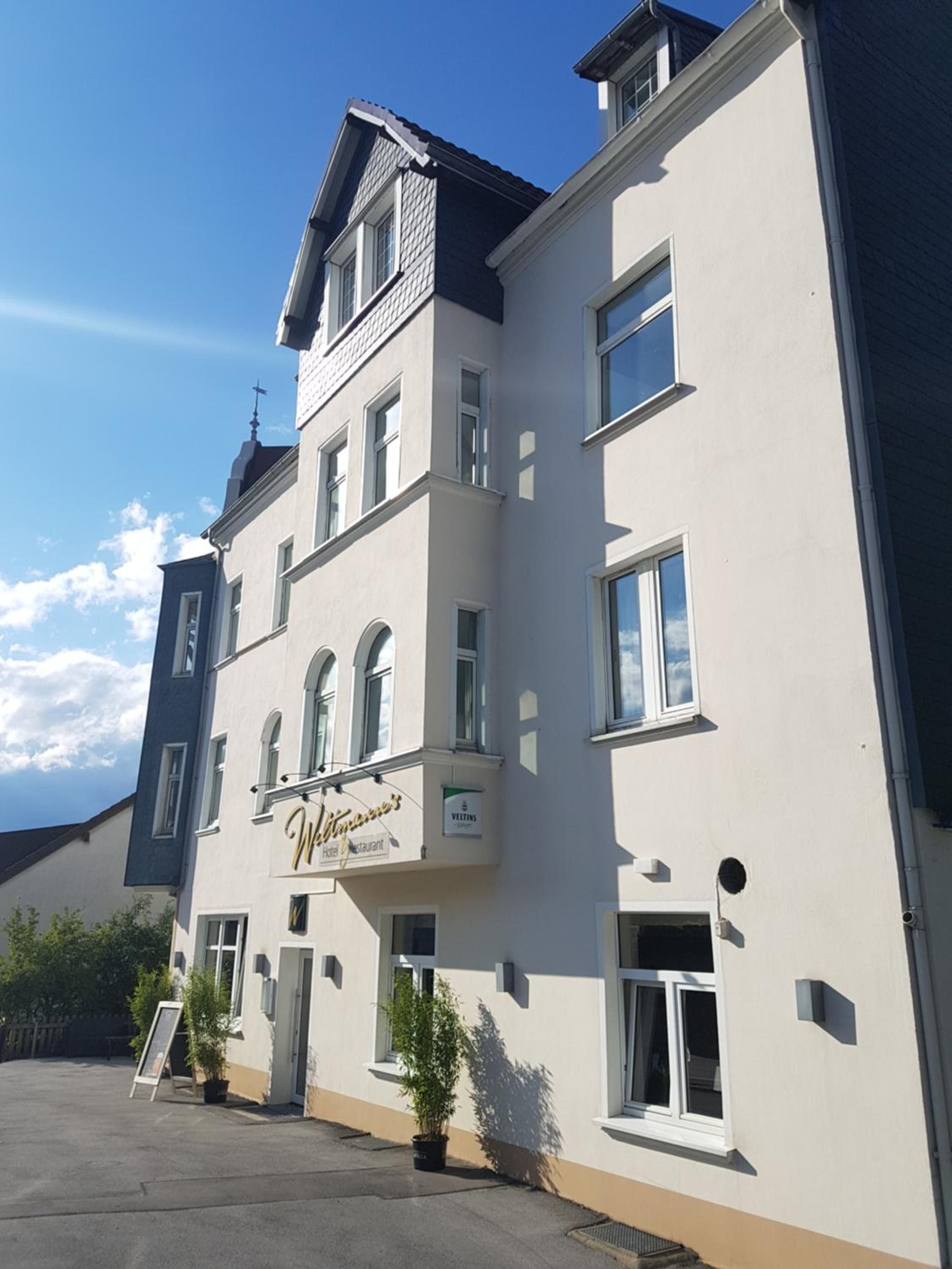 Un edificio a più piani che ospita un hotel e un ristorante, indicato da una segnaletica.