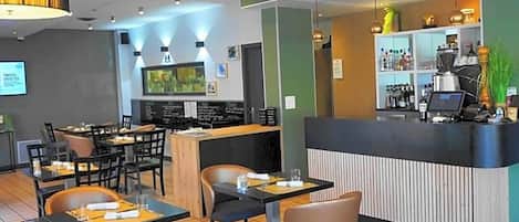 A restaurant with a counter, tables, chairs, and a bar area.
