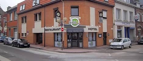 A corner building with a restaurant and hotel sign.