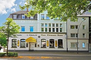 Ein mehrstöckiges Gebäude mit einem Geschäft im Erdgeschoss, das ein gelbes Markisenvorzelt und Beschilderung hat.
