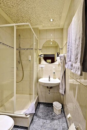 Ein Badezimmer mit Duschkabine, Waschbecken und Toilette.