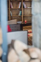 A blurred view of a room with a bookshelf, a desk, and a red candle.