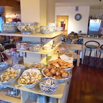 Disposição de buffet com diversos alimentos e acompanhamentos.