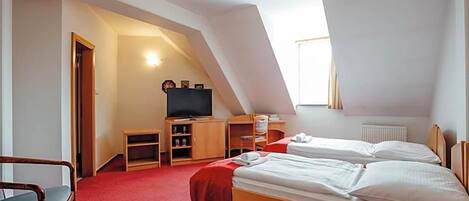 A room with two beds, a television, and a small desk.
