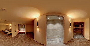 Un interior moderno con un pasillo curvo, suelo de madera y una zona de estar con sillones acolchados.