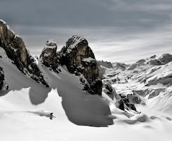Un paisaje montañoso cubierto de nieve con afloramientos rocosos.