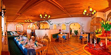 Un restaurante con techo de madera, varias mesas y sillas.