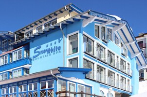A multi-story building with a blue facade and a sign that reads 'Snowwhite Mountain Spa.'